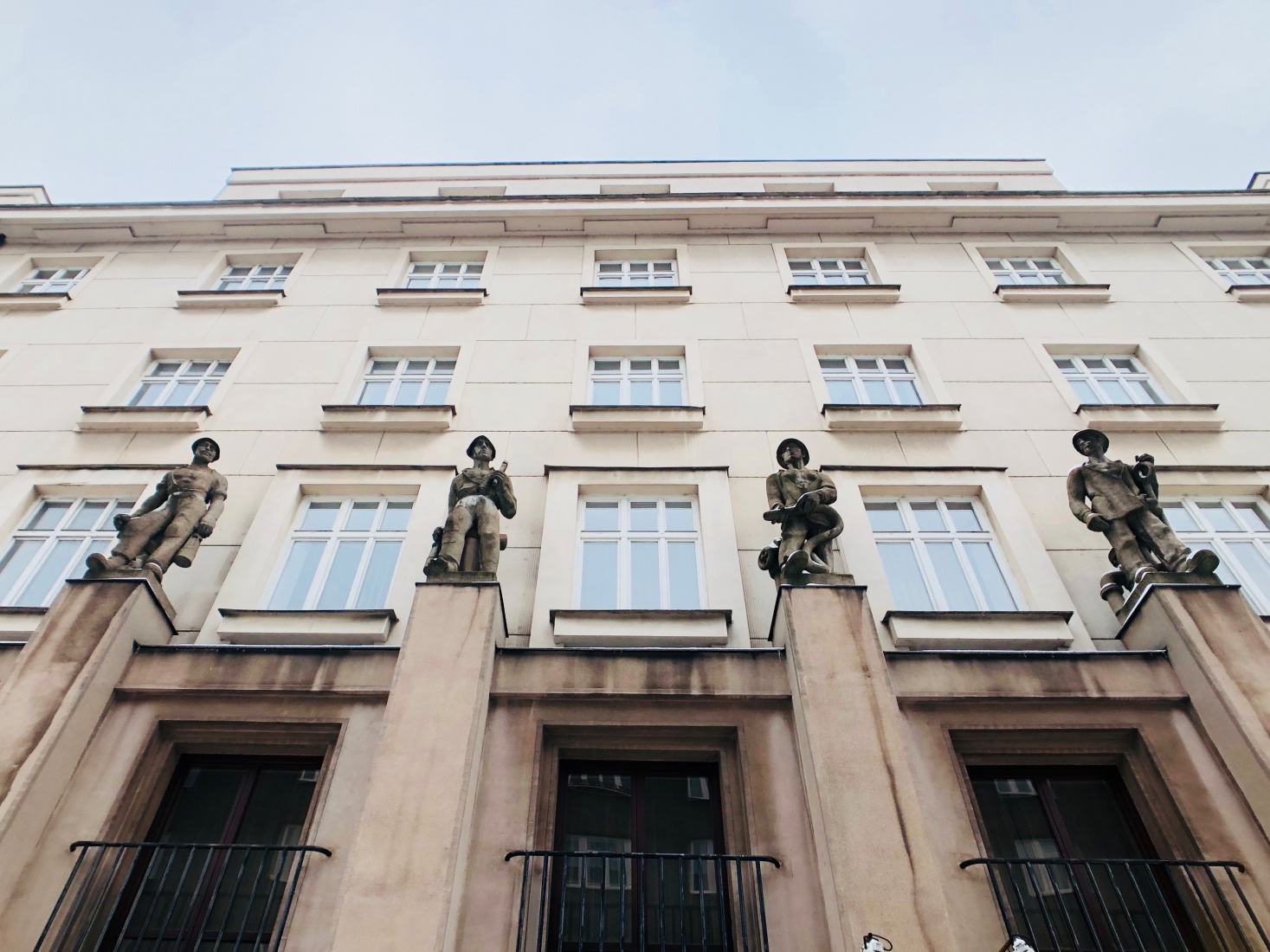 Details of a building with minimal adornments, statues of WWI soldiers are the most decoration on the building, as was common in newly-democratic Czechoslovakia post World War I. Ostrava, Czech Republic.
